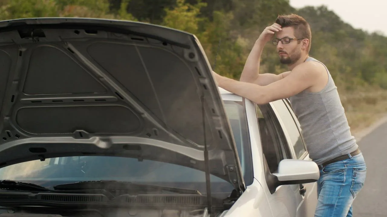 Driver frustrated by a broken down car on the side of the road