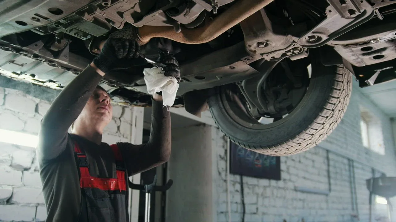 Mechanic working underneath a vehicle during service